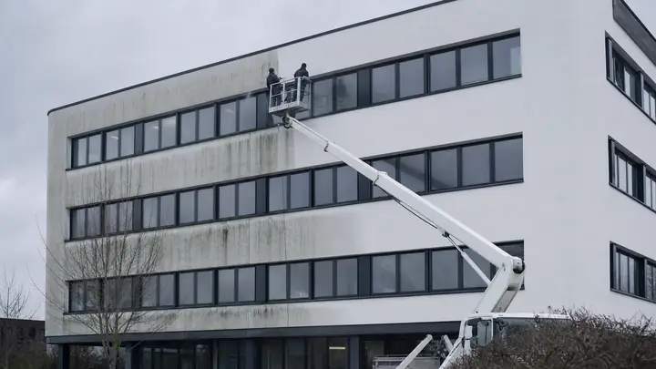 Fassadenreinigung mit Hubarbeitsbühne an einem weißen Bürogebäude